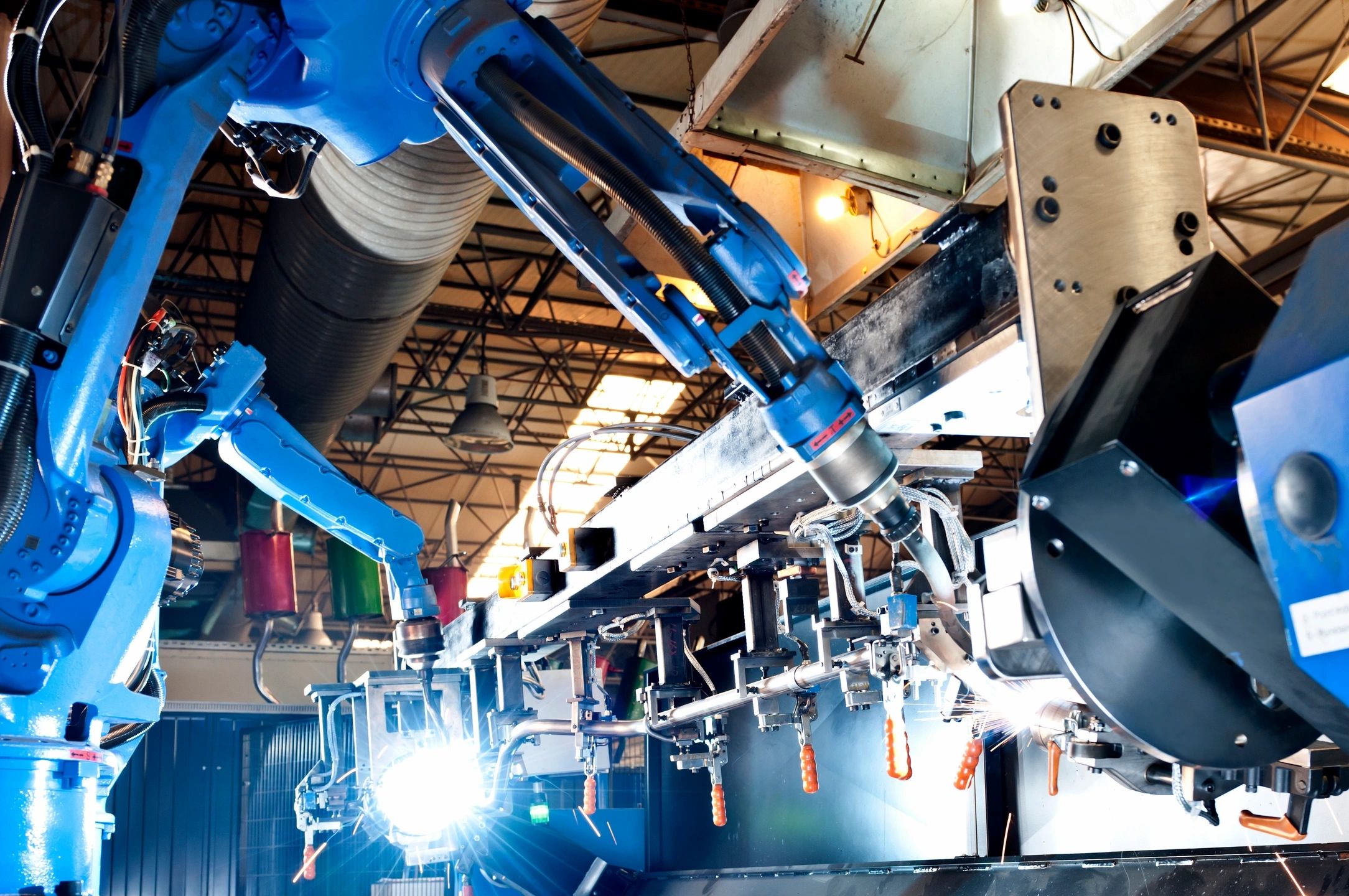 A robot arm is shown in the middle of a factory.